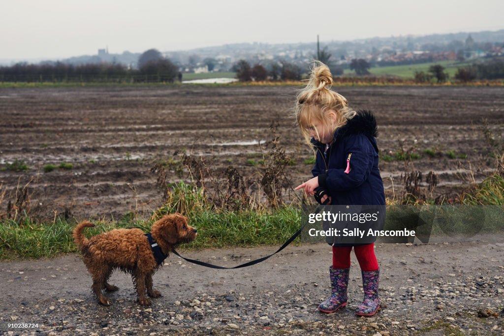 Child walking her puppy dog