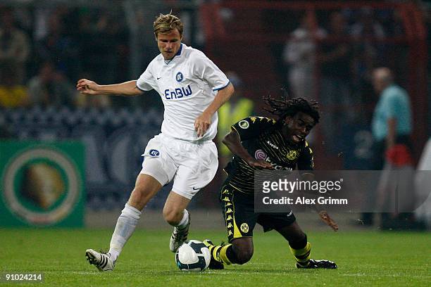 Tinga of Dortmund is challenged by Marco Engelhardt of Karlsruhe during the DFB Cup second round match between Karlsruher SC and Borussia Dortmund at...