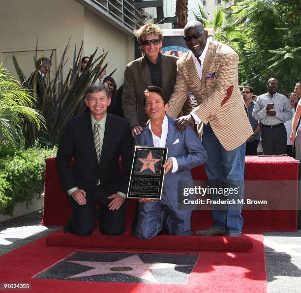 Leron Gubler, recording artist Dave Koz, Barry Manilow and Chris Gardner pose for photographers during ceremony honoring Koz with a star on the...