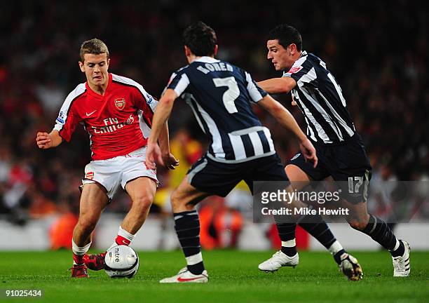 Jack Wilshere of Arsenal is challenged by Robert Koren and Graham Dorrans of West Bromwich Albion during the Carling Cup third round match between...