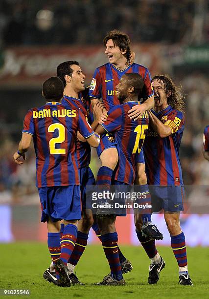 Lionel Messi of Barcelona is lifted up by Seydou Keita after scoring Barcelona's fourth goal against Racing Santander during the La Liga match...