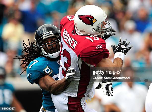 Kurt Warner of the Arizona Cardinals is tackled by Rashean Mathis of the Jacksonville Jaguars during the game at Jacksonville Municipal Stadium on...