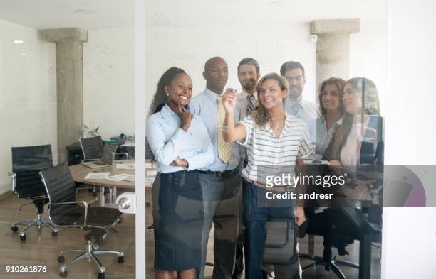 オフィスで目に見えない画面上を書くビジネス グループ - the invisibility project ストックフォトと画像
