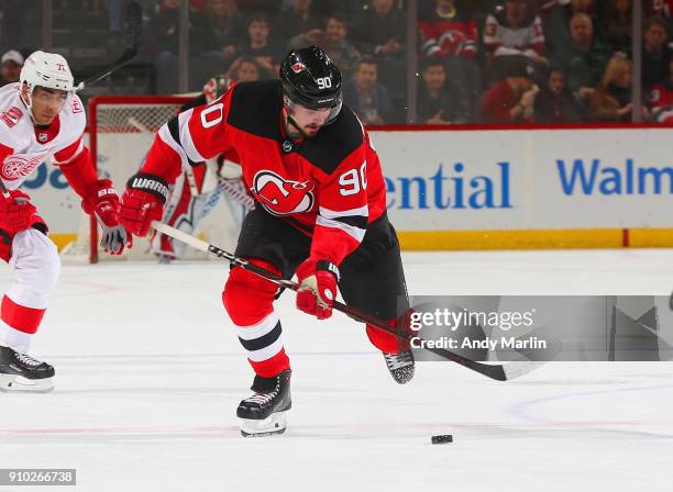 Marcus Johansson of the New Jersey Devils plays the puck during the game against the Detroit Red Wings at Prudential Center on January 22, 2018 in...