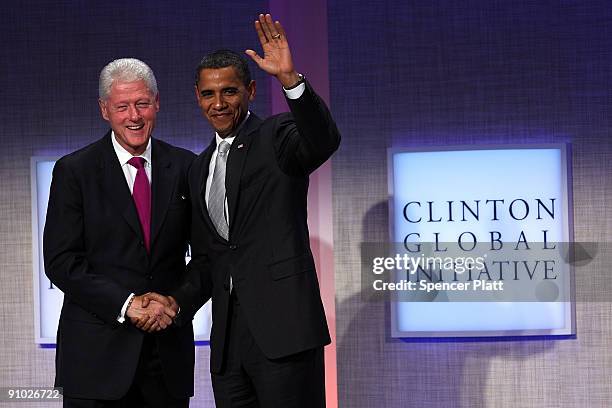 President Barack Obama stands with former President Bill Clinton before speaking at the Fifth Annual Meeting of the Clinton Global Initiative on...