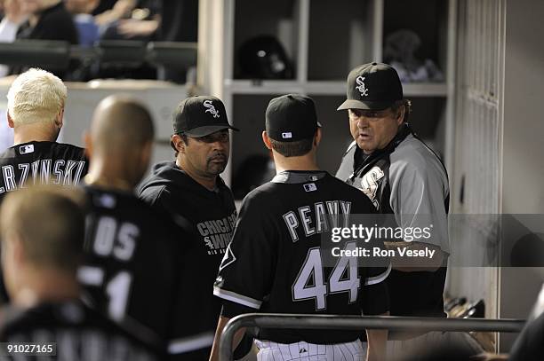 Jake Peavy talks to manager Ozzie Guillen and pitching coach Don Cooper of the Chicago White Sox in the dugout during the game against the Kansas...