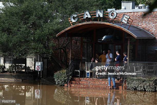 With water still up to the front stairs, people gather at the entrance of the Canoe Restaurant September 22, 2009 in Vinings, Georgia. Excessive rain...