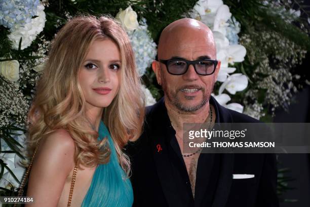 French singer Pascal Obispo and his wife model Julie Hantson pose upon arriving to the Diner de la Mode fundraiser dinner, to benefit the French...