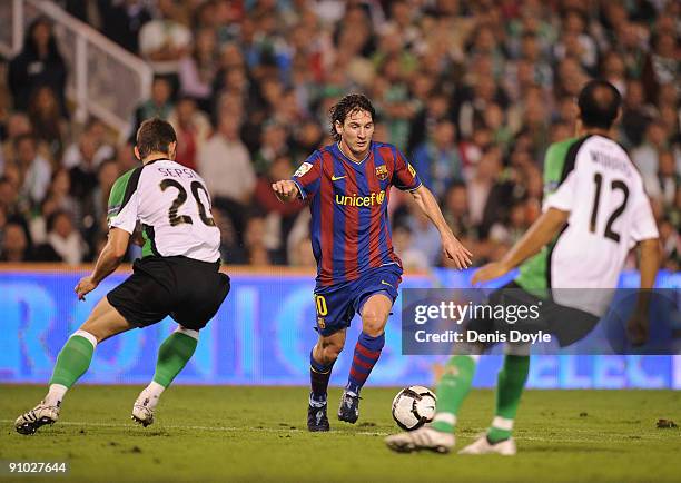 Lionel Messi of Barcelona takes on Nasief Morris and Laszlo Sepsi of Racing Santander during the La Liga match between Racing Santander and Barcelona...