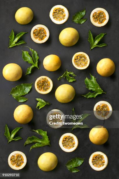 flat lay passion fruits pattern on textured back background. - passion fruit stock pictures, royalty-free photos & images