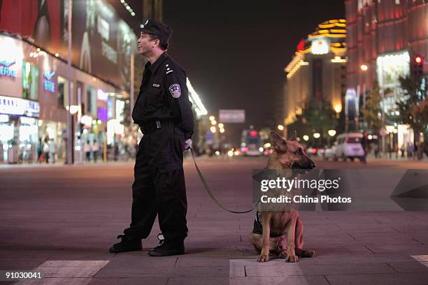 Policeman leads a police dog to patrol at the Wangfujing Pedestrian Street on September 22, 2009 in Beijing, China. Security has been tightened as...