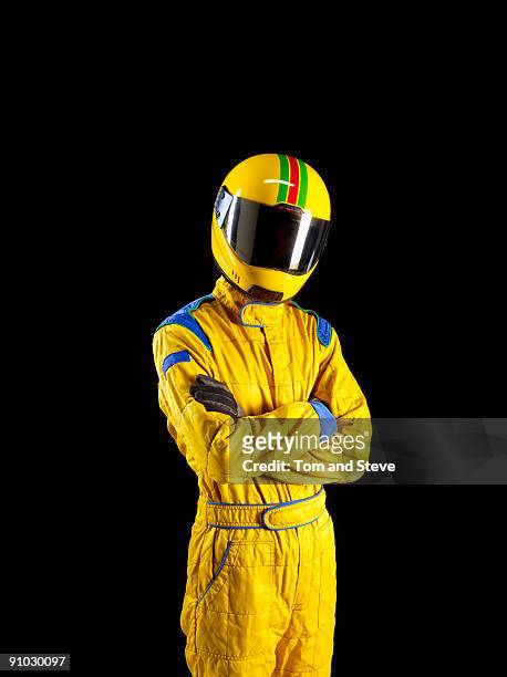 racing driver standing proud on black background. - racing car driver stock-fotos und bilder
