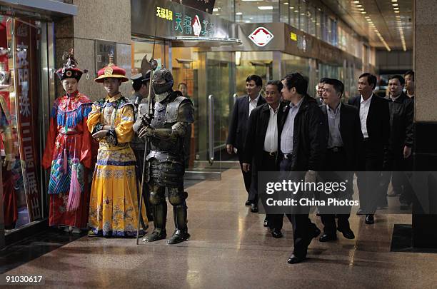 Sales staffs dressed as the Qing Dynasty empress, emperor and a knight, stand in front of a shop to attract customers at the Wangfujing Pedestrian...