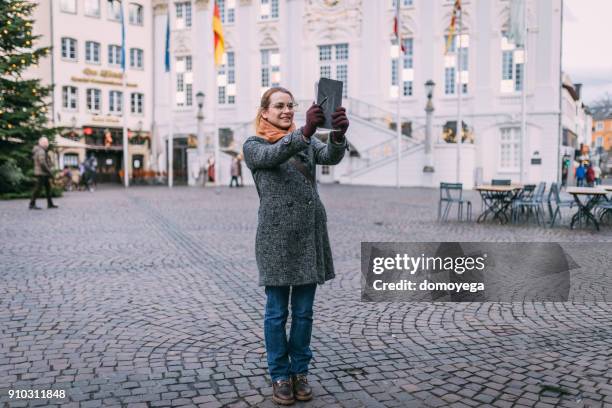 casual dressed woman using digital tablet outdoors in germany - bonn stock pictures, royalty-free photos & images