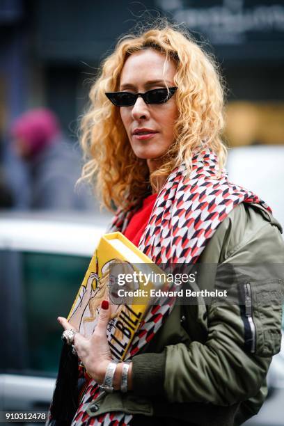 Elina Halimi wears sunglasses, a scarf, a red top, a skirt, a yellow Kill Bill clutch, outside AF Vandervorst, during Paris Fashion Week -Haute...