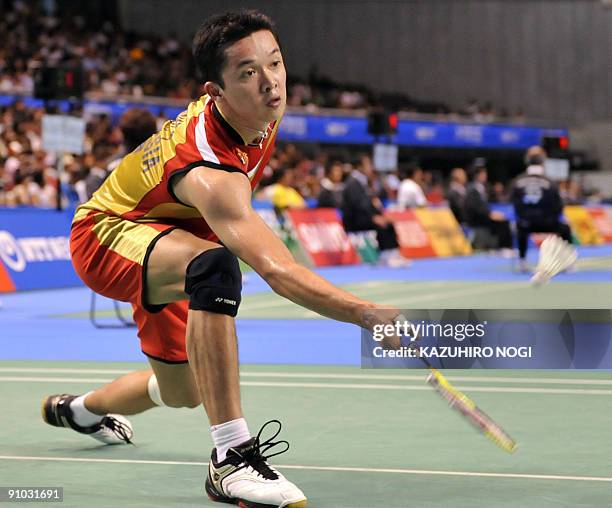 Taufik Hidayat of Indonesia hits a return against Chan Yan-kit of Hong Kong during their men's singles first round match at the Japan Open badminton...