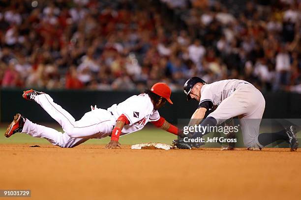 Brett Gardner of the New York Yankees slides safely past shortstop Erick Aybar of the Los Angeles Angels of Anaheim and steals second base in the...