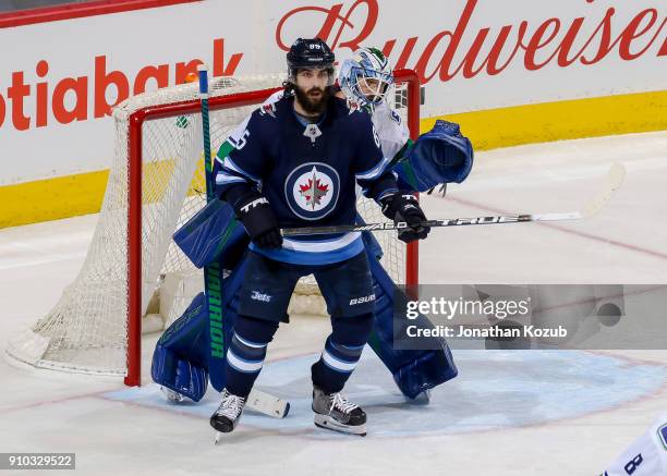 Mathieu Perreault of the Winnipeg Jets sets a screen in front of goaltender Anders Nilsson of the Vancouver Canucks during third period action at the...