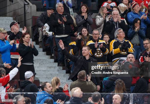 Chris Neil formerly of the Ottawa Senators, salutes the fans as he is honored for his 1,026 NHL games played with the team, during a game against the...