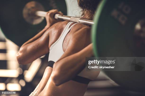mujer musculoso irreconocible haciendo fuerza ejercicios con barra en un gimnasio. - culturismo fotografías e imágenes de stock