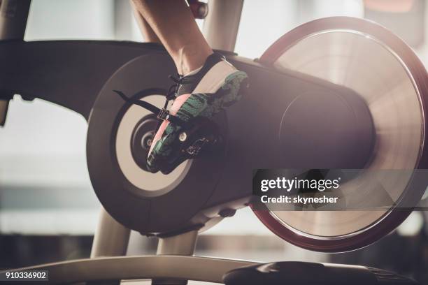 méconnaissable athlète ayant un cours de spinning sur vélo stationnaire dans une salle de gym. - cours de spinning photos et images de collection