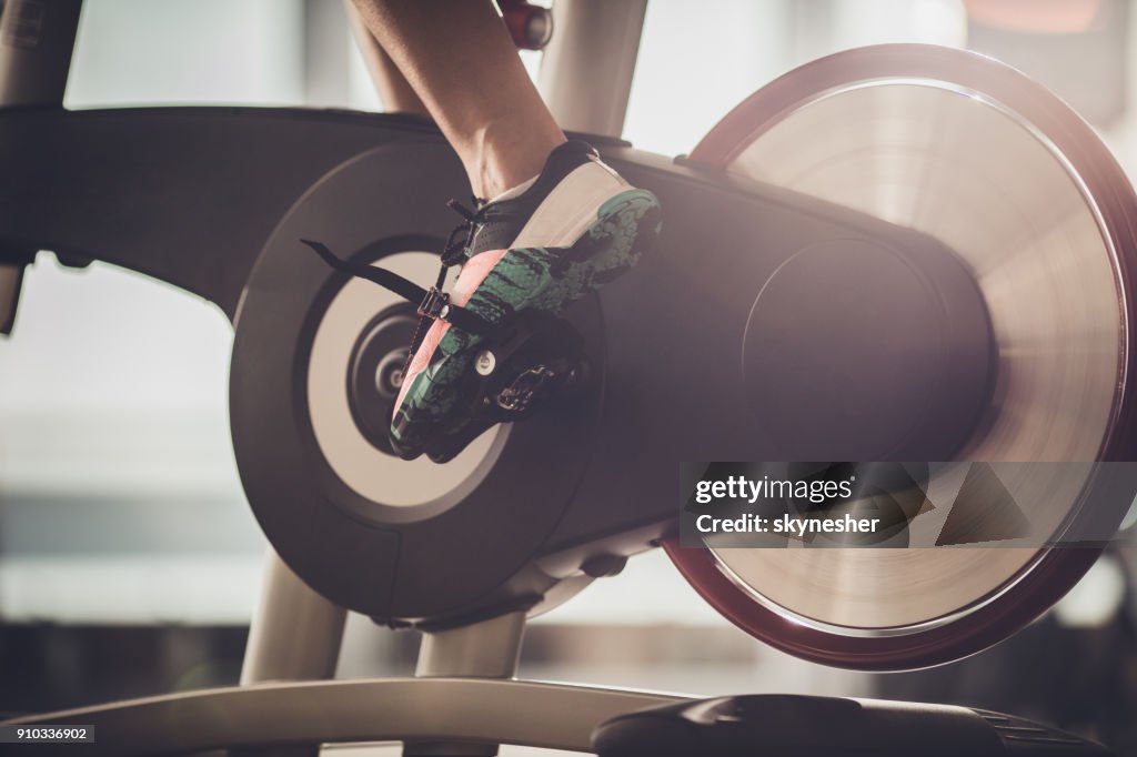 Unrecognizable athlete having a exercising class on stationary bike in a gym.