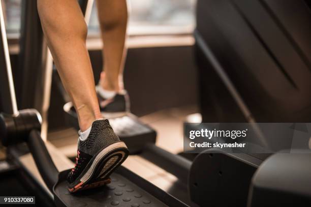 close up of unrecognizable athlete warming up on cross trainer in a gym. - runner warming up stock pictures, royalty-free photos & images