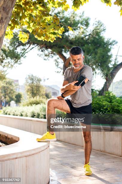 runner man lacing shoes - running spikes stock pictures, royalty-free photos & images