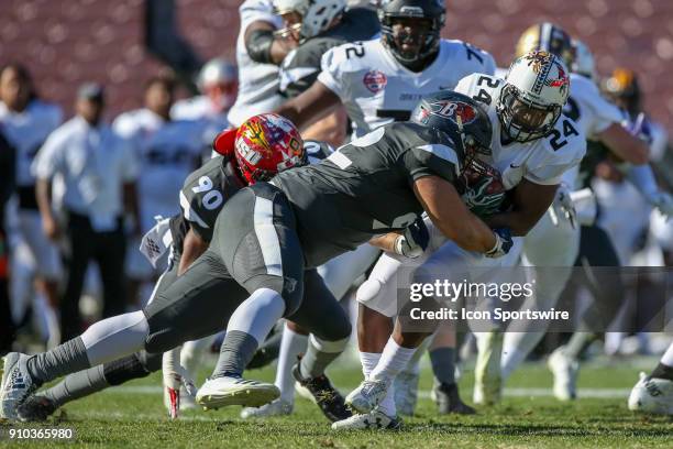 National defensive tackle Abdullah Anderson from Bucknell University tackles American running back Diocemy Saint Juste from Hawaii during the NFLPA...