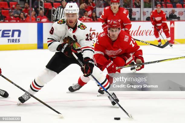 Jonathan Toews of the Chicago Blackhawks looks to get a shot off in front of Dylan Larkin of the Detroit Red Wings during the third period at Little...