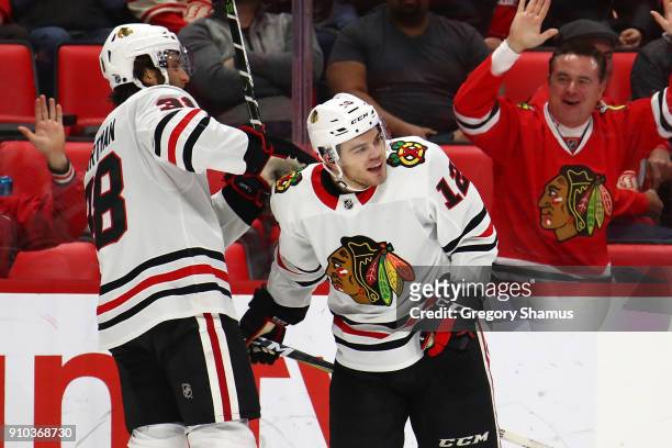 Alex DeBrincat of the Chicago Blackhawks celebrates a hat trick with a empty net goal with Ryan Hartman while playing the Detroit Red Wings at Little...