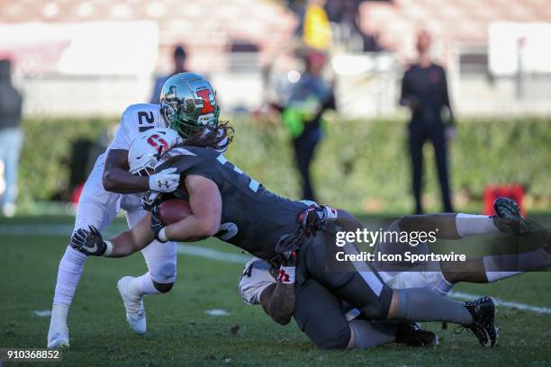 National fullback Daniel Marx from Stanford gets tackled by American defensive back Devin Abraham from South Florida during the NFLPA Collegiate Bowl...