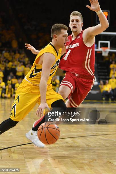 Iowa guard Jordan Bohannon drives around Wisconsin Badgers guard Brevin Pritzl during a Big Ten Conference basketball game between the Wisconsin...