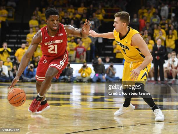 Wisconsin Badgers forward Khali Iverson is closely guarded by Iowa guard Jordan Bohannon in the first half during a Big Ten Conference basketball...