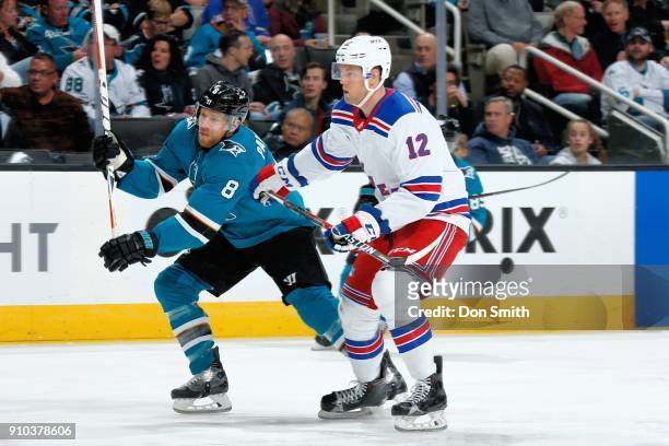 Joe Pavelski of the San Jose Sharks is defended by Peter Holland of the New York Rangers at SAP Center on January 25, 2018 in San Jose, California.