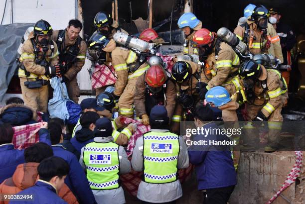 In this handout picture provided by the Kim Gu Yeon-Gyeongnam Domin Ilbo, Rescue workers remove bodies from a hospital fire on January 26, 2018 in...