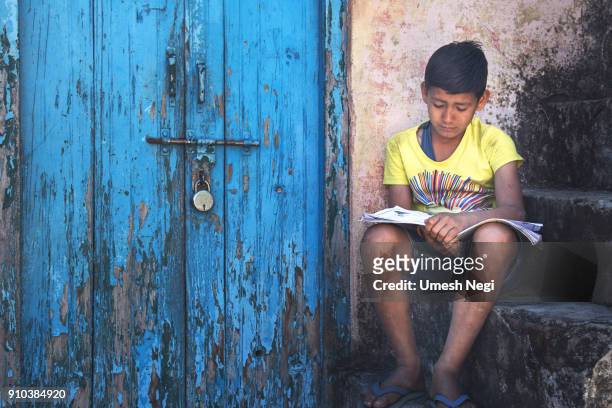 kind in der nähe von verschlossenen tür lesen - indian school children stock-fotos und bilder