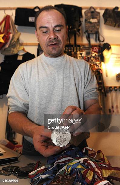 Former German shot putter Andreas Krieger, who competed as a woman on the East German athletics team, shows his medals during an interview in his...