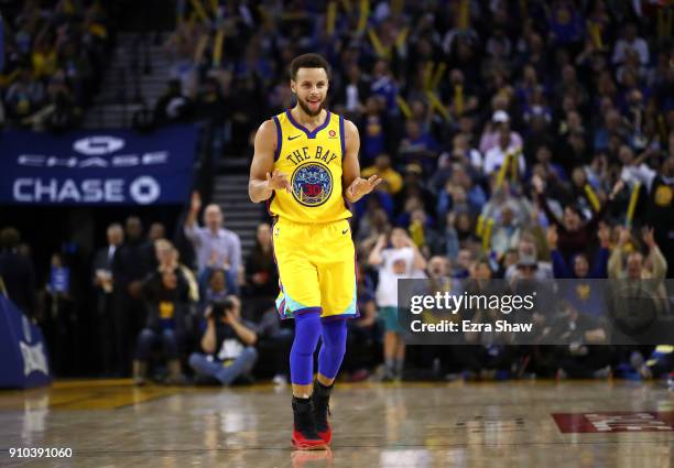 Stephen Curry of the Golden State Warriors reacts after Kevin Durant made a basket against the Minnesota Timberwolves at ORACLE Arena on January 25,...