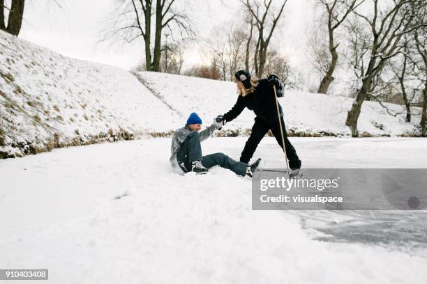 helping friend in hockey match - person slipping on ice stock pictures, royalty-free photos & images