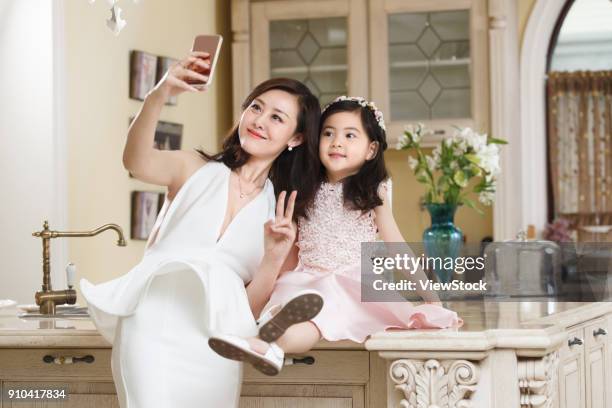 the fashionable mother and daughter in dress are taking pictures - kitchen dresser stock pictures, royalty-free photos & images