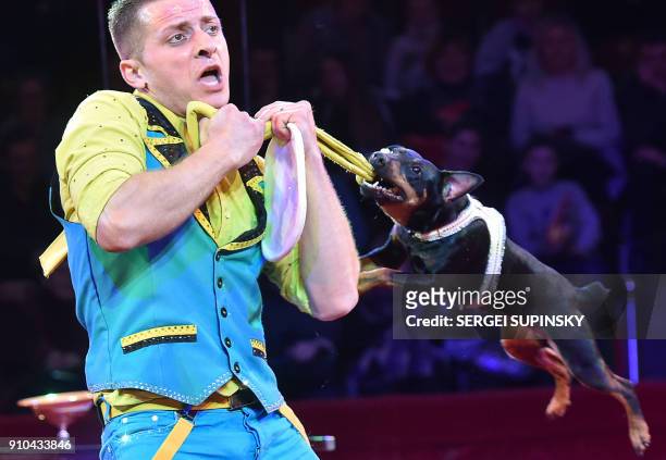Liviu Tudor of Romania performs with a dog during the premiere show of the new program in the national circus in the Ukrainian capital of Kiev on...