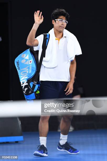 Dejected Hyeon Chung of South Korea waves to the crowd after retiring hurt in his semi-final match against Roger Federer of Switzerland on day 12 of...