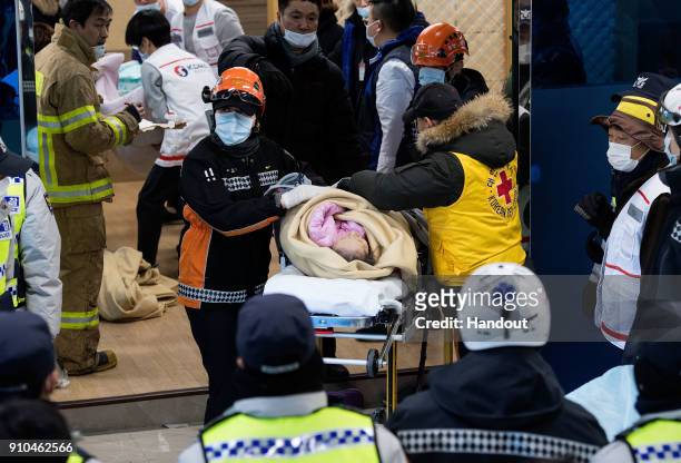 In this handout image provided by the Kookje Shinmun, Rescue workers carry a patient on January 26, 2018 in Miryang, South Korea. 37 people were...