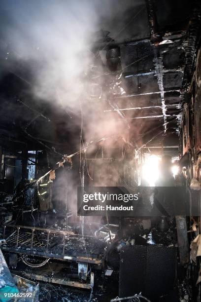 In this handout image provided by the Kookje Shinmun, Firefighters inspects a burnt hospital after a fire on January 26, 2018 in Miryang, South...