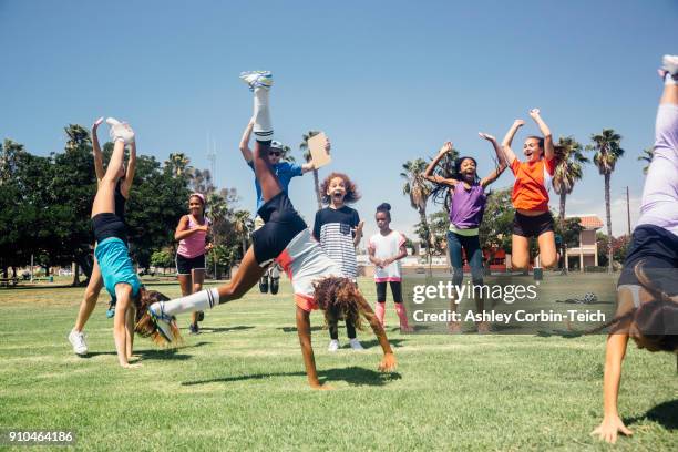 schoolgirl soccer team doing cartwheel celebration on school sports field - fille sport photos et images de collection