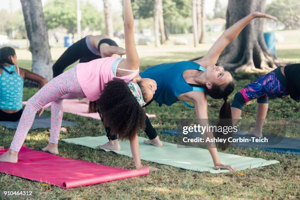 schoolgirls practicing yoga pose on school playing field - endast flickor bildbanksfoton och bilder