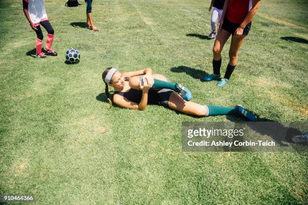 Schoolgirl soccer player lying injured on school sports field