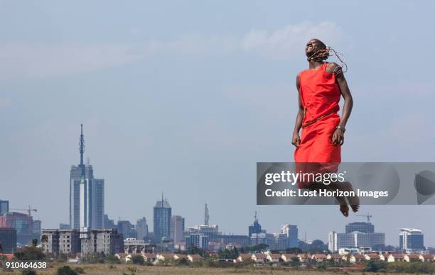 masai warrior jumping in mid air during traditional dance, nairobi, kenya, africa - nairobi cityscape stock pictures, royalty-free photos & images