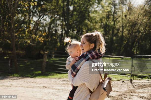 mother carrying young daughter, in rural setting - oshawa 個照片及圖片檔